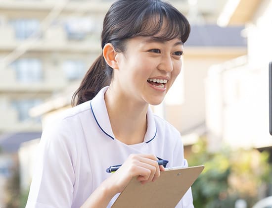 カルテを持ち笑顔の女性看護師